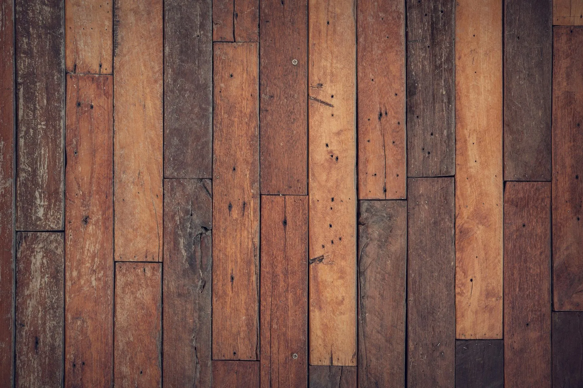 Wood paneling with varying shades of brown, arranged in vertical planks.